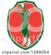 Poster, Art Print Of Retro Silhouetted Green Basketball Player Jumping And Shooting In A Green White And Red Shield