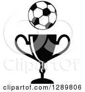 Clipart Of A Black And White Soccer Ball Over A Championship Trophy Royalty Free Vector Illustration