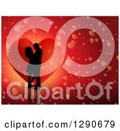 Clipart Of A Black Silhouetted Couple Kissing Over A Red Heart And Reflective Background Royalty Free Vector Illustration