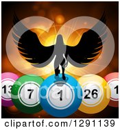 Clipart Of A Black Silhouetted Female Angel Kneeling On 3d Giant Bingo Or Lottery Balls Against Orange Flares And A Burst Royalty Free Vector Illustration by elaineitalia