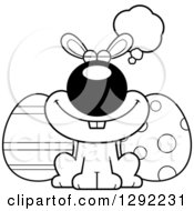 Holiday Clipart Of A Black And White Cartoon Dreaming Or Thinking Happy Easter Bunny With Eggs Royalty Free Lineart Vector Illustration