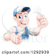 Poster, Art Print Of Happy Brunette Middle Aged White Male Electrician Giving A Thumb Up And Holding A Light Bulb