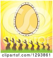 Clipart Of An Easter Egg Frame And Swirling Sky Over Silhouetted Rabbits In Grass Royalty Free Vector Illustration