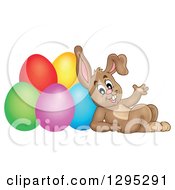 Poster, Art Print Of Brown Easter Bunny Rabbit Waving And Leaning Against Colorful Easter Eggs