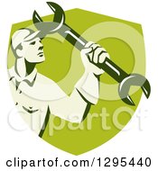 Clipart Of A Retro Male Mechanic Holding Up A Wrench In A Green Shield Royalty Free Vector Illustration