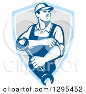 Clipart Of A Retro Male Mechanic Rolling Up His Sleeves And Holding A Wrench In A Blue White And Gray Shield Royalty Free Vector Illustration