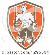 Clipart Of A Retro Male Crossfit Or Gymnast Athlete Doing Kipping Pull Ups On Still Rings In A Brown White And Orange Shield Royalty Free Vector Illustration by patrimonio