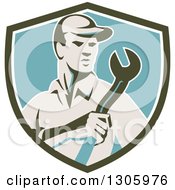 Clipart Of A Retro Male Mechanic Holding A Giant Wrench In An Olive Green White And Blue Shield Royalty Free Vector Illustration