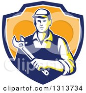 Clipart Of A Retro Male Mechanic Holding A Giant Adjustable Wrench In A Blue White And Orange Shield Royalty Free Vector Illustration