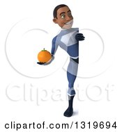 Clipart Of A 3d Full Length Young Black Male Super Hero Dark Blue Suit Holding A Navel Orange And Looking Around A Sign Royalty Free Illustration