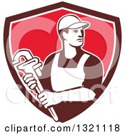 Clipart Of A Retro Male Plumber Holding A Monkey Wrench And Looking To The Side In A Brown White And Red Shield Royalty Free Vector Illustration
