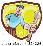 Clipart Of A Cartoon White Male Mechanic Holding Out A Wrench And Emerging From A Brown White And Green Shield Royalty Free Vector Illustration