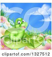 Cartoon Happy Green Worm On A Leaf Over Flowers In A Meadow