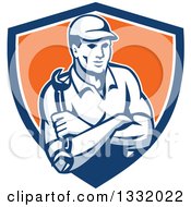 Clipart Of A Retro Male Mechanic Holding A Wrench In Folded Arms In A Blue White And Orange Shield Royalty Free Vector Illustration