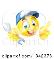 Poster, Art Print Of Cartoon Yellow Emoji Emoticon Plumber Or Mechanic Wearing A Baseball Cap Holding A Wrench And Giving A T Humb Up
