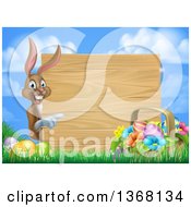 Brown Easter Bunny Rabbit With Eggs And A Basket Pointing Around A Blank Wood Sign Against Sky