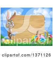 Poster, Art Print Of Brown Easter Bunny Rabbit With Eggs And A Basket Pointing Around A Blank Wood Sign Against Sky