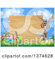 Poster, Art Print Of Brown Bunny Rabbit With Eggs And An Easter Basket Pointing Around A Blank Wood Sign Against Sky