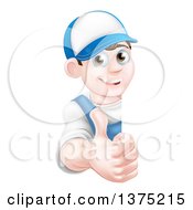 Happy Young Brunette Caucasian Mechanic Man In Blue Wearing A Baseball Cap Giving A Thumb Up Around A Sign