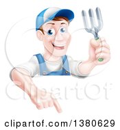 Middle Aged Brunette White Male Gardener In Blue Holding A Garden Fork And Pointing Down Over A Sign