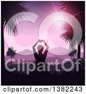 Relaxed Silhouetted Woman Doing Yoga Between Palm Trees Against A Tropical Mountainous Sunset