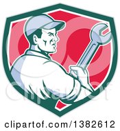 Clipart Of A Retro Male Mechanic Holding A Giant Wrench In A Gray Green White And Red Shield Royalty Free Vector Illustration