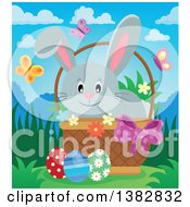 Poster, Art Print Of Happy Gray Easter Bunny Rabbit In A Basket Of Eggs With Spring Flowers And Butterflies On A Sunny Day