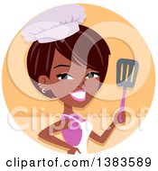 Pretty Black Baker Woman Holding Up A Spatula In An Orange Circle