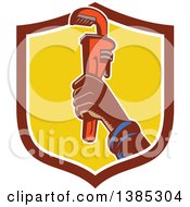 Clipart Of A Retro Woodcut Plumbers Hand Holding Up A Monkey Wrench In A Shield Royalty Free Vector Illustration
