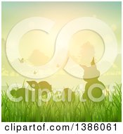 Poster, Art Print Of Silhouetted Bunny Rabbits With Butterflies And An Egg In Grass Against A Sunset
