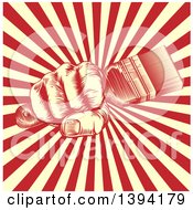 Clipart Of A Retro Woodcut Fist Holding A Paintbrush Over Yellow And Red Rays Royalty Free Vector Illustration