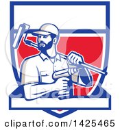 Clipart Of A Retro Handyman Holding A Paint Roller Over His Shoulder And A Cordless Drill In Hand Emerging From A Shield With A Blank Banner Royalty Free Vector Illustration