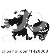 Poster, Art Print Of Black And White Silhouetted Halloween Witch Pushing A Jackolantern In A Wagon