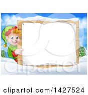 Poster, Art Print Of Happy Caucasian Male Christmas Elf Pointing Aorund A Blank Sign In A Winter Landscape
