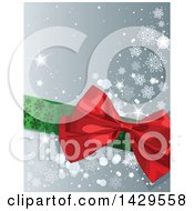 Green Ribbon And Red Christmas Gift Bow Over A Gray Background With Snowflakes And Sparkles