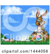 Poster, Art Print Of Happy Brown Easter Bunny With A Basket Of Eggs And Flowers In The Grass Against A Blue Sky