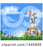 Poster, Art Print Of Happy Easter Bunny With A Basket Of Eggs And Flowers In The Grass Against A Blue Sky