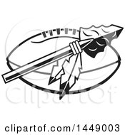 Clipart Of A Black And White Arrowhead With Feathers Over An American Football Royalty Free Vector Illustration