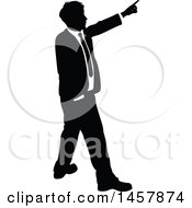 Clipart Of A Black And White Silhouetted Business Man Pointing Royalty Free Vector Illustration
