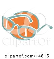 Pair Of Orange And Green Sunglasses Over An Orange Circle