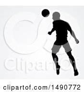 Poster, Art Print Of Silhouetted Male Soccer Player Heading A Ball Over Gray