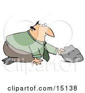 Businessman In A Green Shirt And Tie Kneeling To Look And See What He Can Discover Under A Rock