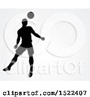 Clipart Of A Silhouetted Male Soccer Player Heading A Ball Over Gray With Text Space Royalty Free Vector Illustration