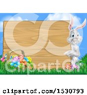 Poster, Art Print Of Happy White Easter Bunny Rabbit Pointing Around A Wood Sign Against Sky