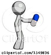 Gray Design Mascot Man Holding Blue Pill Walking To Right