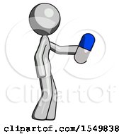 Gray Design Mascot Woman Holding Blue Pill Walking To Right