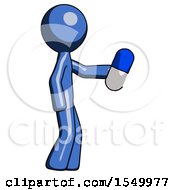 Blue Design Mascot Man Holding Blue Pill Walking To Right