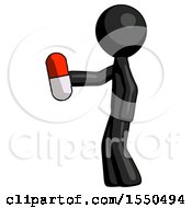 Black Design Mascot Man Holding Red Pill Walking To Left