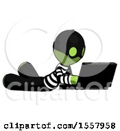 Poster, Art Print Of Green Thief Man Using Laptop Computer While Lying On Floor Side Angled View