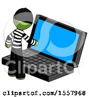 Green Thief Man Using Large Laptop Computer
